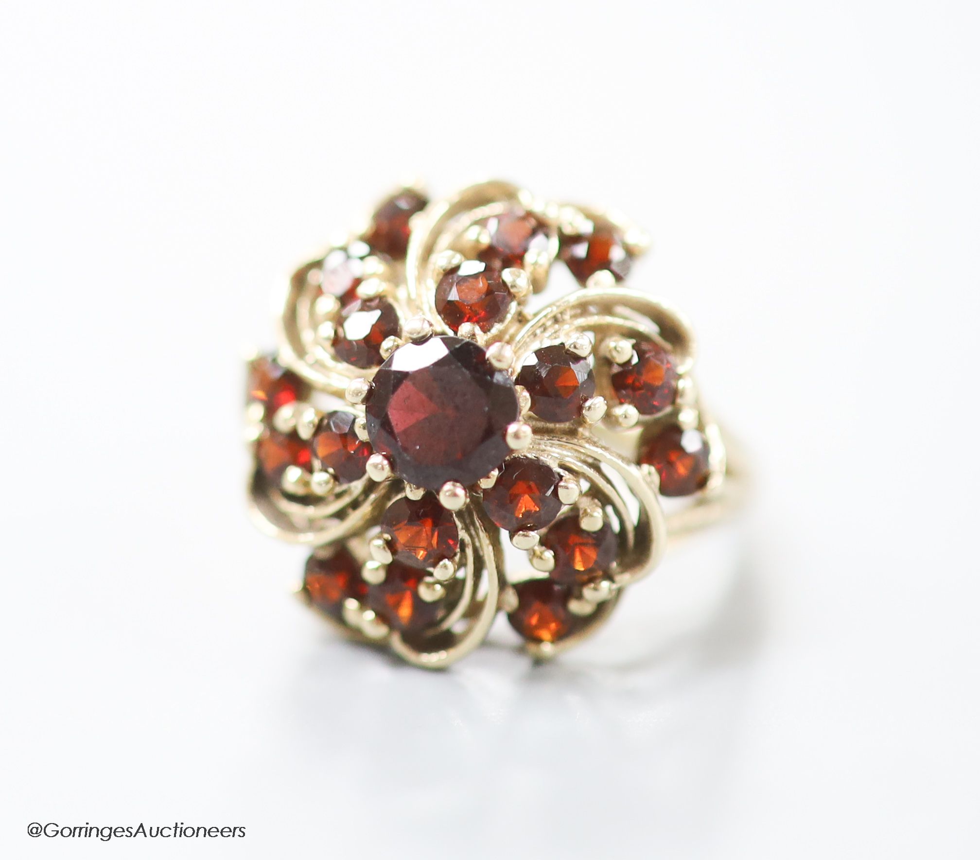 A modern 14ct gold and garnet cluster dress ring, size M/N, gross 7.4 grams